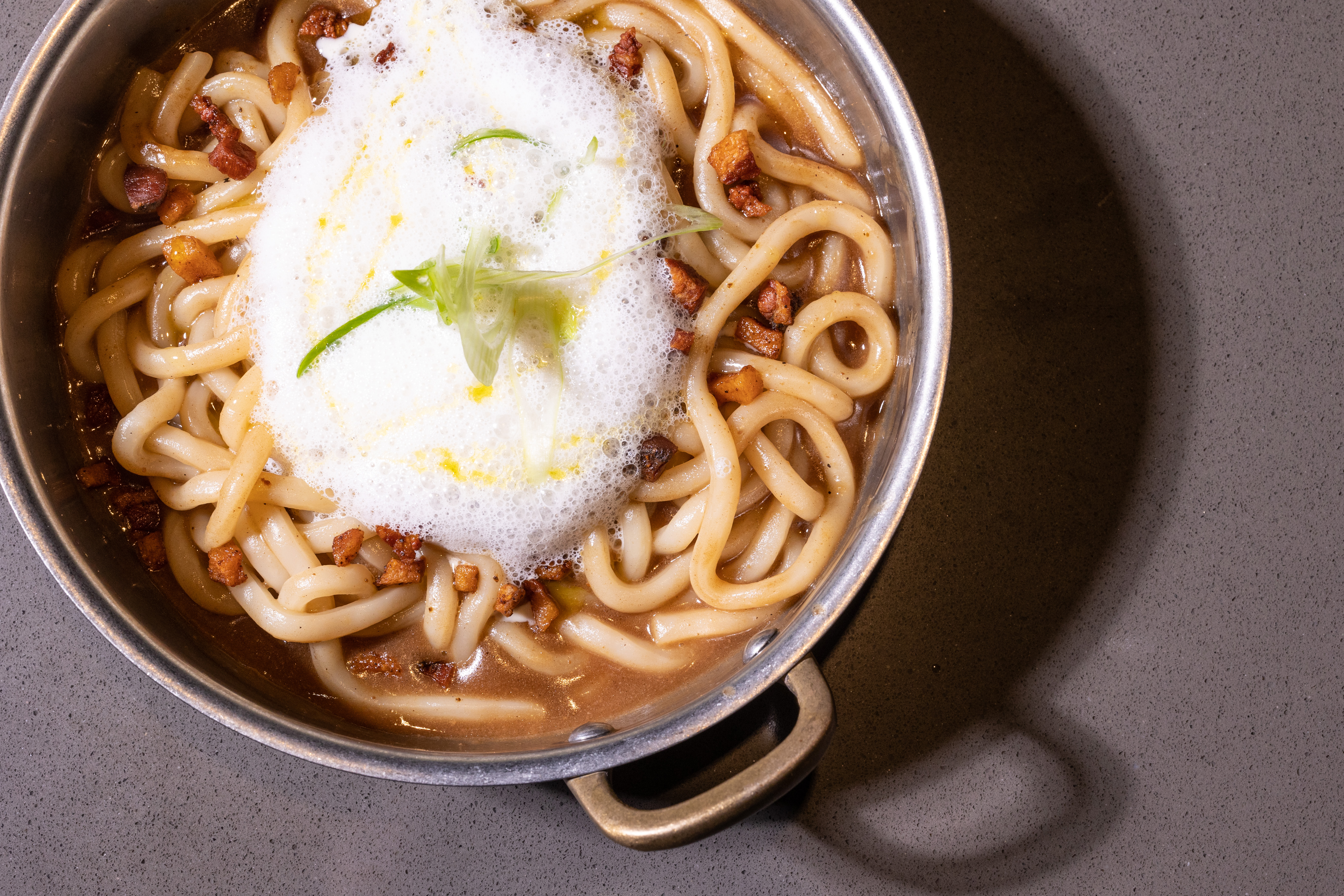 Udon con salsa de calamar a la brasa, guanciale y aire de queso.